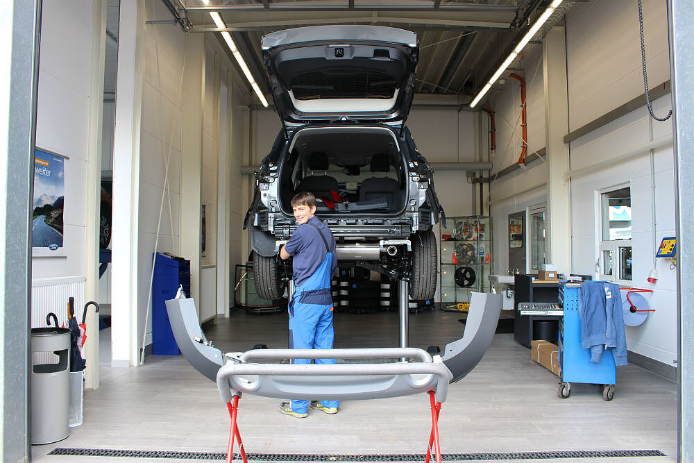 Auto auf eine Hebebühne mit einem Mechaniker